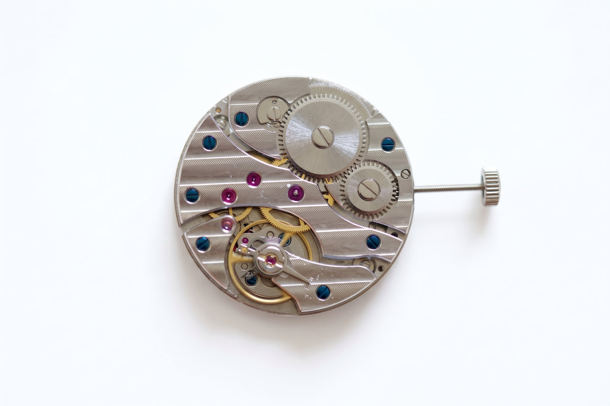 A circular ST36 watch movement with visible screws, wheels, and jewel bearings, photographed on a wooden surface.
ST36 top view